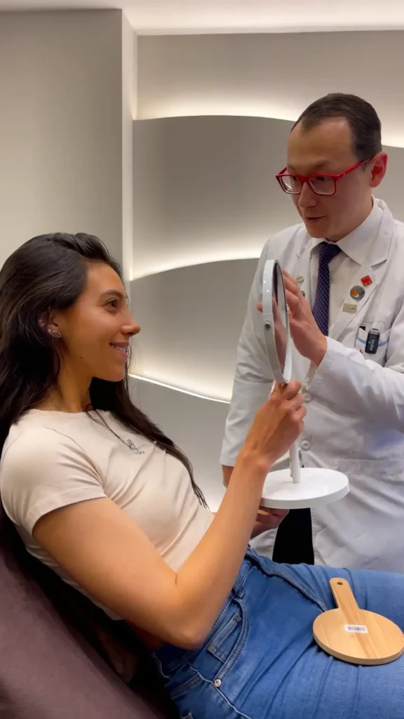Paciente satisfecha en consulta con el Dr. Minyor Avellaneda, cirujano plástico experto en resultados naturales.