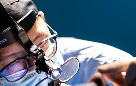 Dr. Minyor Avellaneda realizando una rinoplastia ultrasónica en Bogotá con equipo de alta precisión en quirófano.